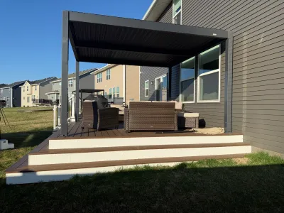 Covered composite deck seating area in Carver with outdoor furniture and a modern pergola-style roof
