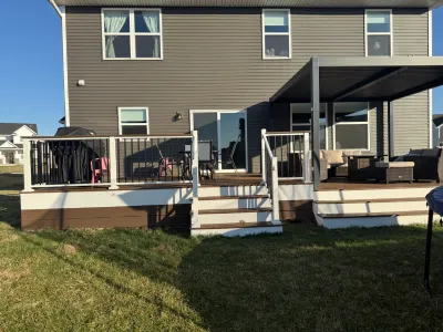 Rear view of the Carver composite deck project showing stairs, railings, and the covered deck section