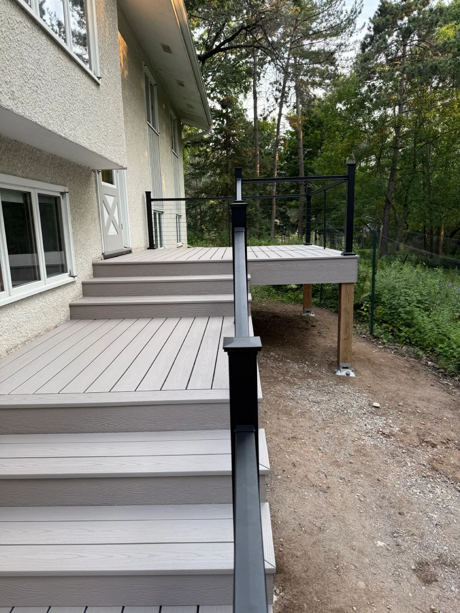 Cottage Grove multi-level composite deck with broad stairs and black cable railings