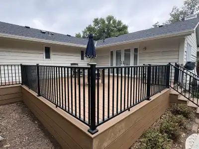 Large Deephaven backyard deck with black aluminum railing and brown low-maintenance deck boards
