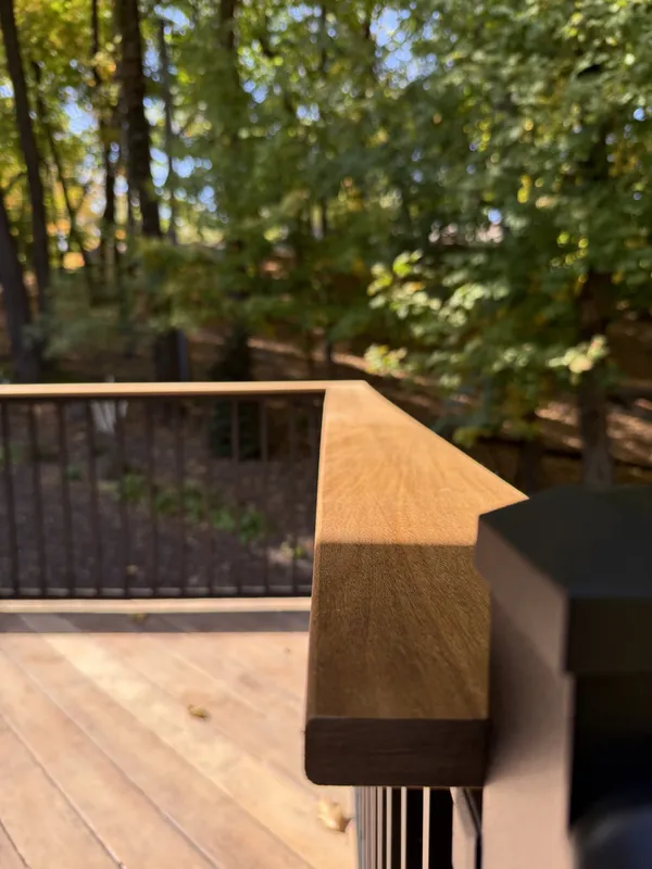 Close view of the brown railing cap meeting a black deck post
