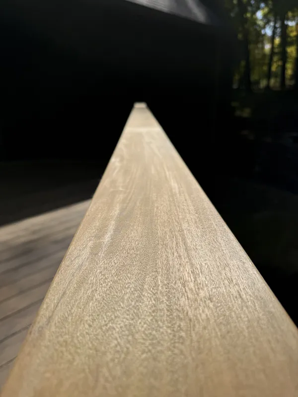 Wood-grain texture along the top of a brown railing cap