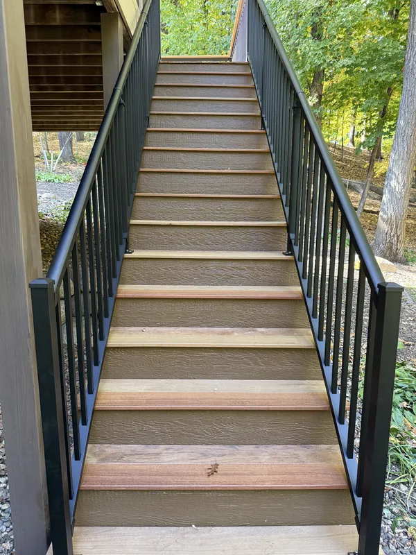 Staircase from the yard to the Deephaven deck with black railings