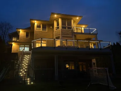 Danny in a red cap working on composite deck stairs and railing finish details