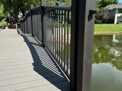 Bridge railing installation with new posts and finished deck surface in Hopkins