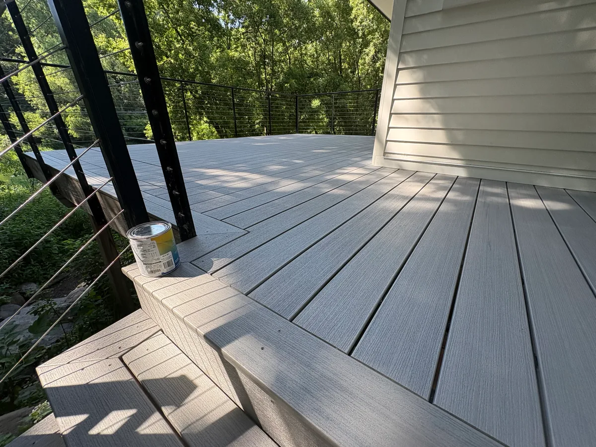 Gray composite deck surface in Hopkins with black cable railing and picture-framed border