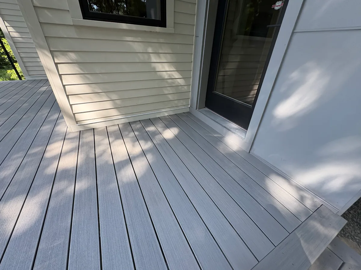 Hopkins gray composite decking installed around an exterior door and wall transition
