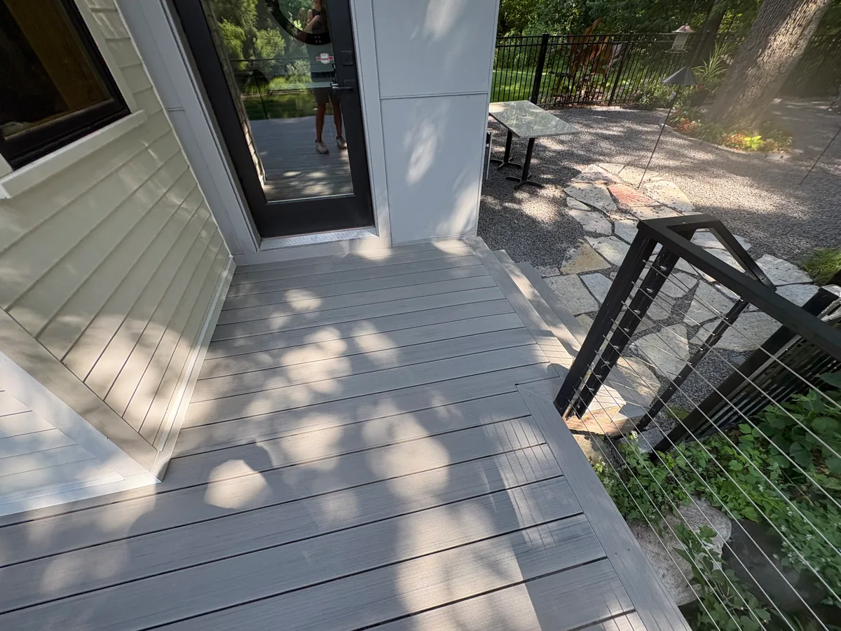 Hopkins deck landing with gray composite boards, black cable railing, and broad stairs