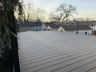Large completed rooftop deck over garage with composite boards and black railings
