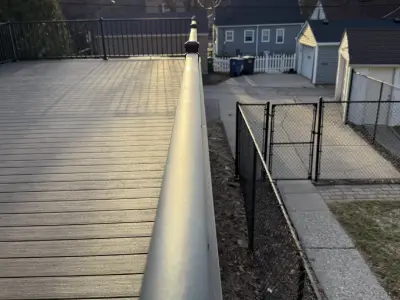Detail shot of black railing beside evergreen trees on a garage deck in Minneapolis