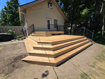 Minneapolis multi-level wood deck project with wide stairs and black aluminum railings.