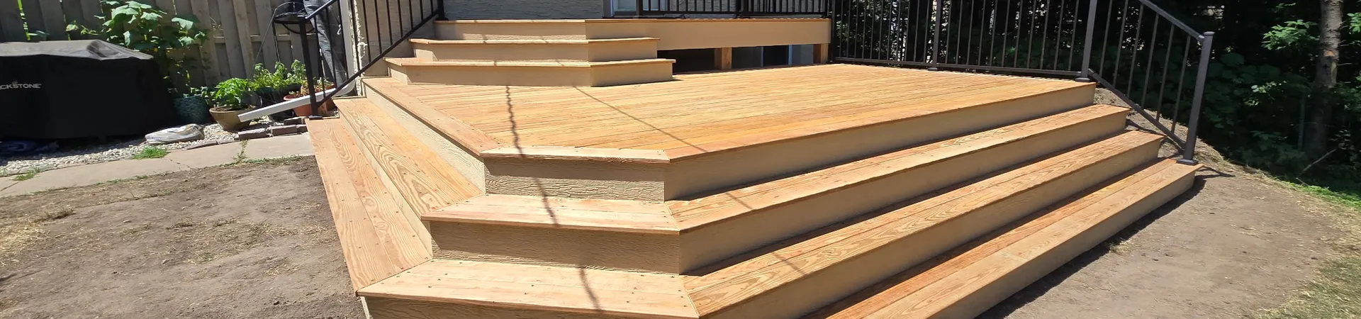 Minneapolis composite wood deck build with black aluminum railings and stairs