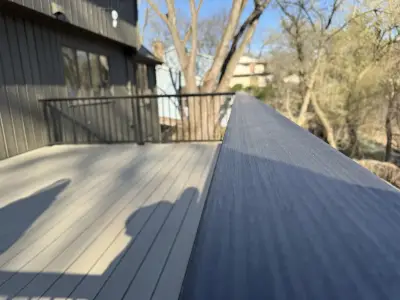 Close-up of composite deck boards and black aluminum railing cap on a Minnetonka deck project