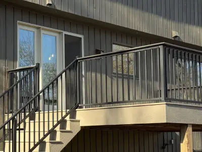 New composite stairs with black railing posts and finished risers on a Minnetonka deck build