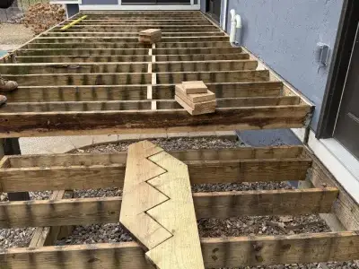 Custom stair stringer layout placed on exposed deck framing during rebuild