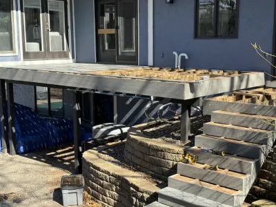 Deck resurfacing progress showing new stair framing and partially installed composite materials