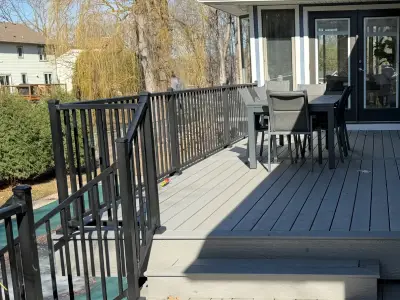 Completed composite deck seating area with black aluminum railings in Minnetonka