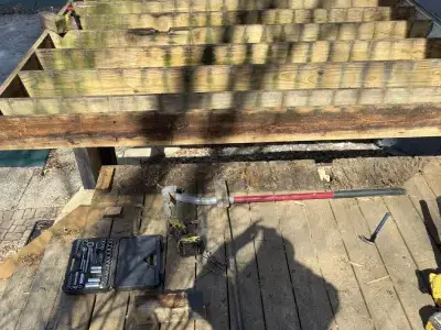 Close-up of old deck boards and exposed framing during deck tear-off
