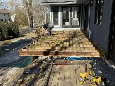 Deck demolition progress showing boards removed and framing exposed