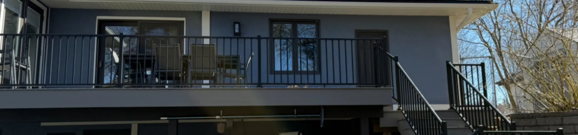 Completed deck resurfacing project in Minnetonka with composite decking, rebuilt stairs, and black aluminum railings