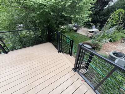Minnetonka composite deck landing with black railings overlooking landscaped backyard