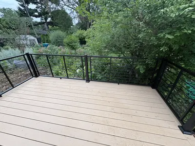 Tan composite deck platform in Minnetonka surrounded by mature landscaping
