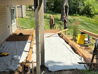 Ground-level deck framing beneath elevated structure in Minnetonka backyard