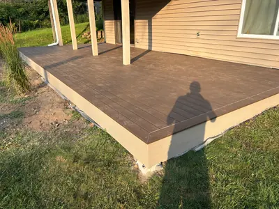 Finished dark brown composite deck surface beneath existing Minnetonka deck