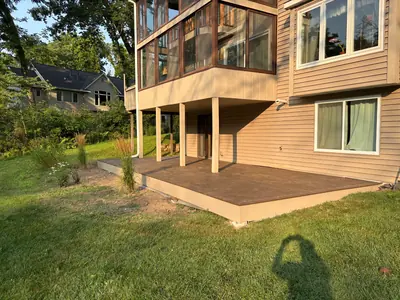Wide ground-level composite deck beneath enclosed upper deck in Minnetonka
