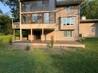 Minnetonka ground-level composite deck built beneath an existing elevated deck with dark brown decking and matching fascia.