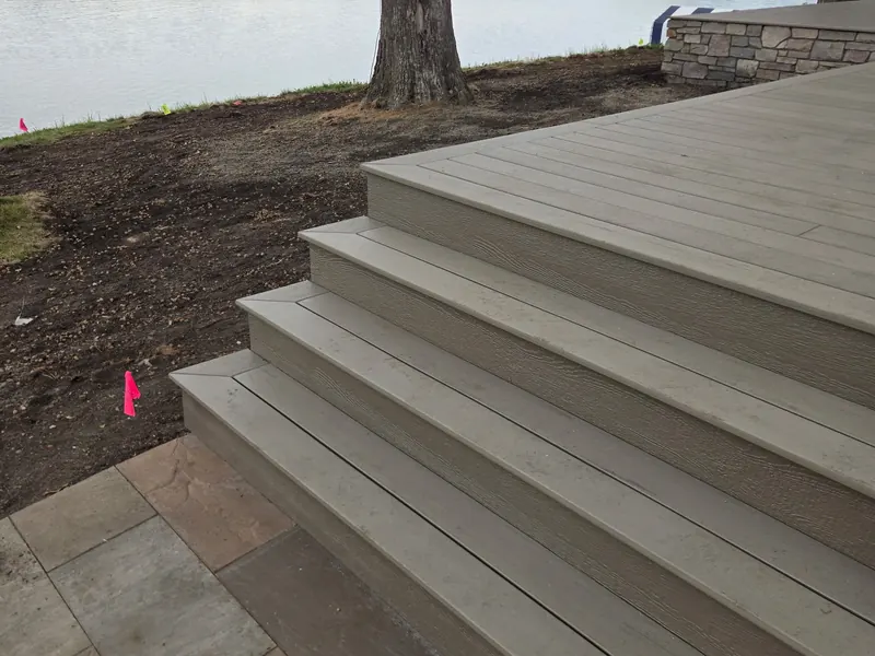 Wide composite deck stairs descending toward the lake in Minnetrista