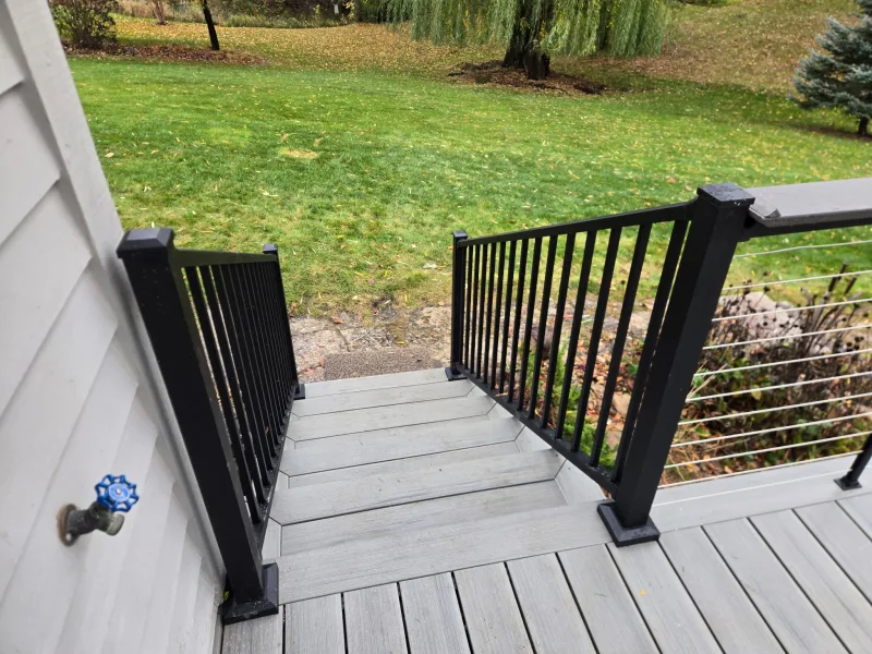 View down the gray deck stairs toward the backyard