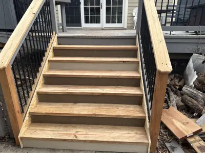 St. Louis Park deck repair project with rebuilt wood stairs and black aluminum railings close us