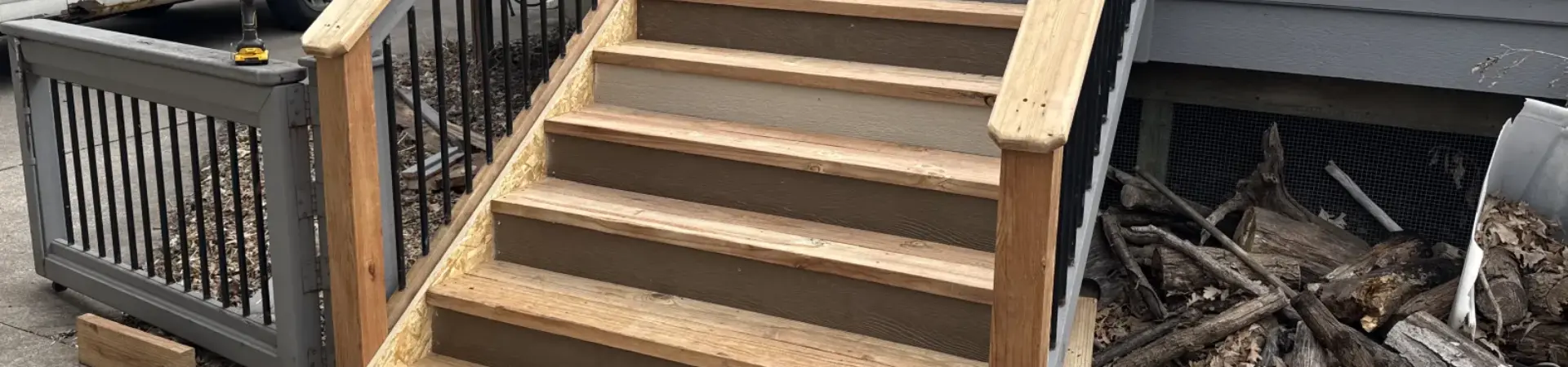 St. Louis Park deck repair project with rebuilt wood stairs and existing black aluminum railings