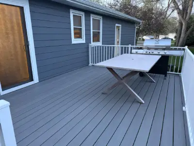 Finished composite deck surface with table and white railings in Wayzata