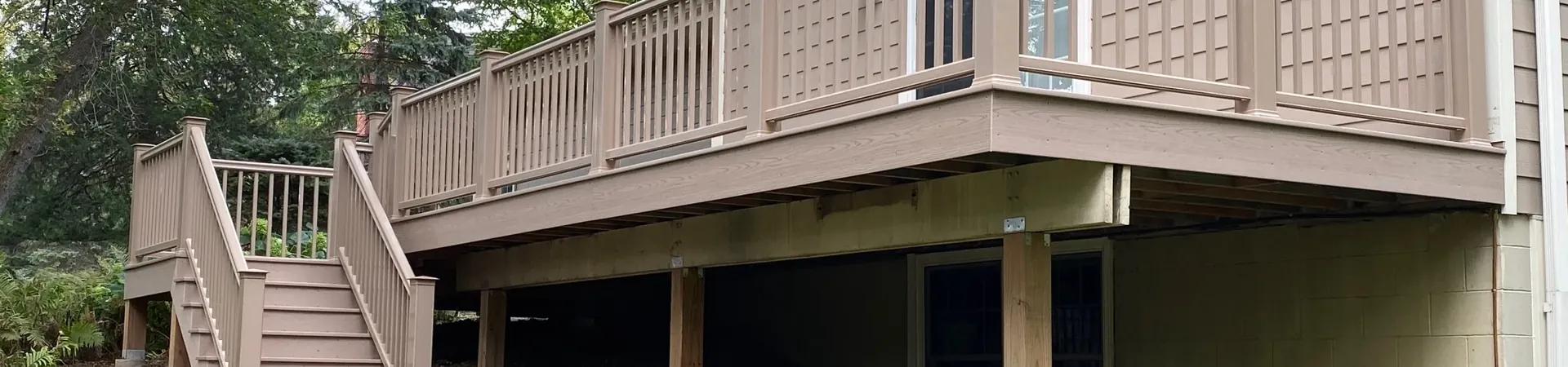 Completed deck with stairs leading to the backyard beside the home