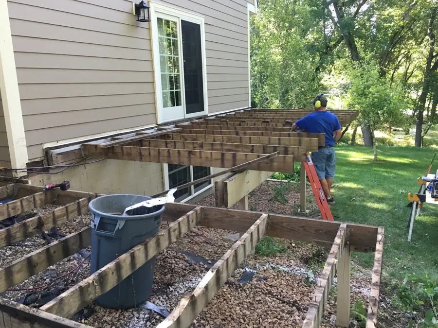 Exposed deck framing beside the house during construction