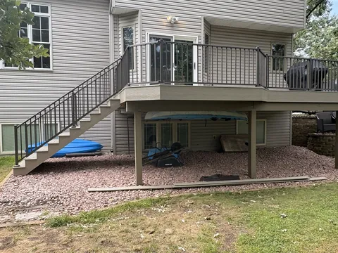Elevated composite deck with long staircase and black metal railing