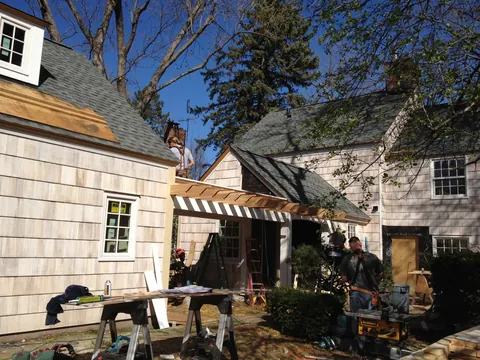 Pergola construction in progress beside a residential home