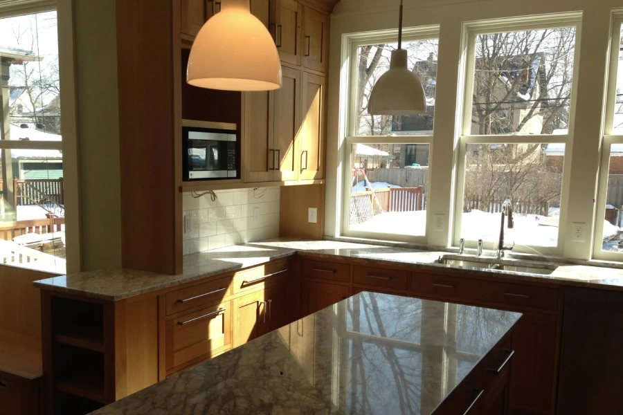 Kitchen remodeling project with updated cabinets, island, and pendant lighting